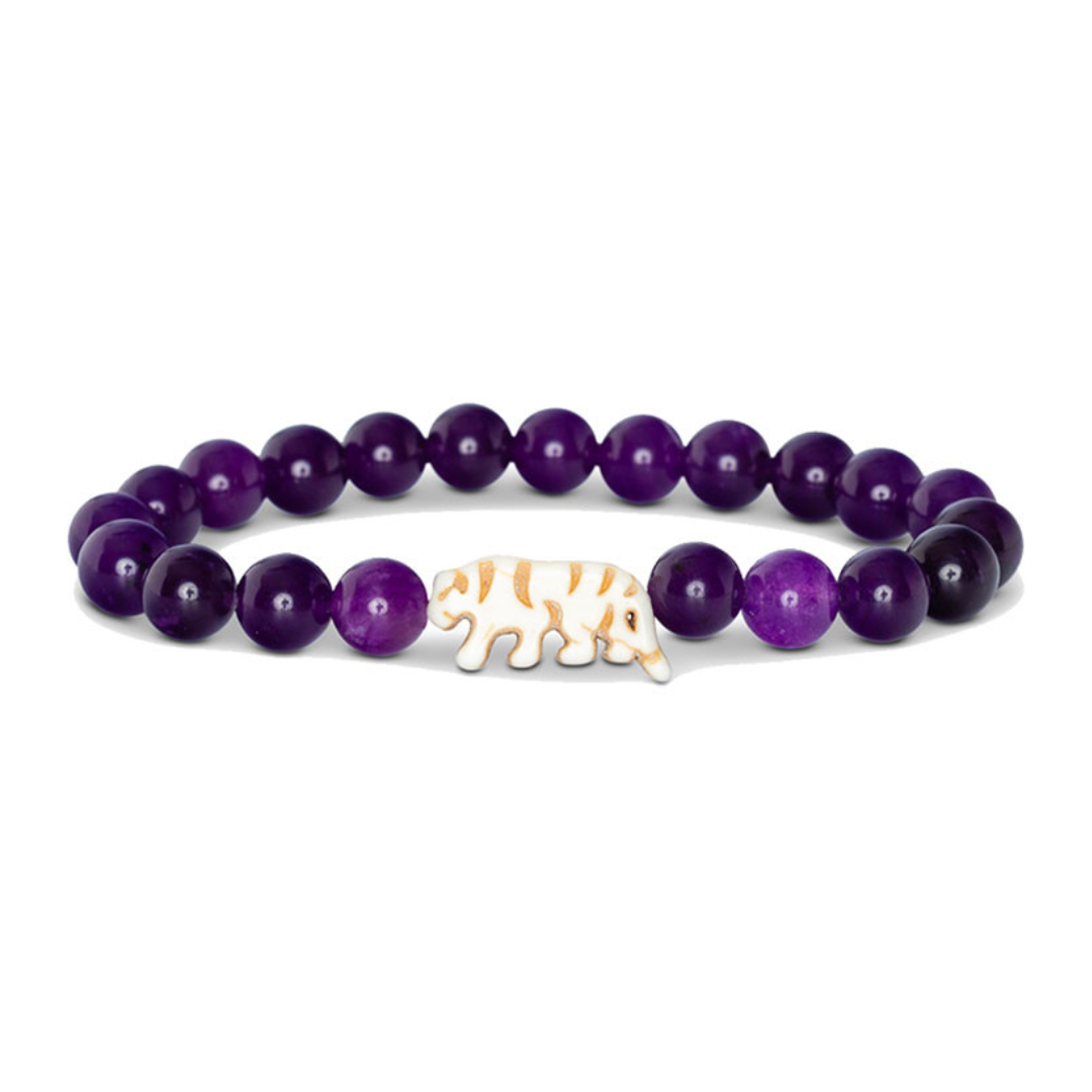 Purple beaded bracelet with a gold tiger head charm on a white background
