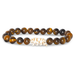 Bracelet with tiger eye beads and a white elephant charm on a white background