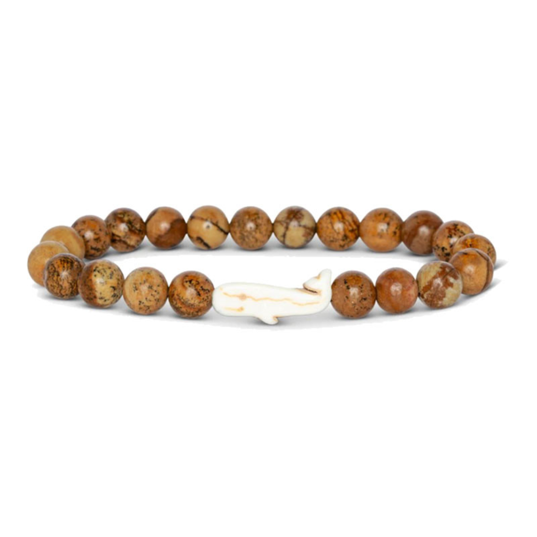 Beaded bracelet with a white charm on a white background