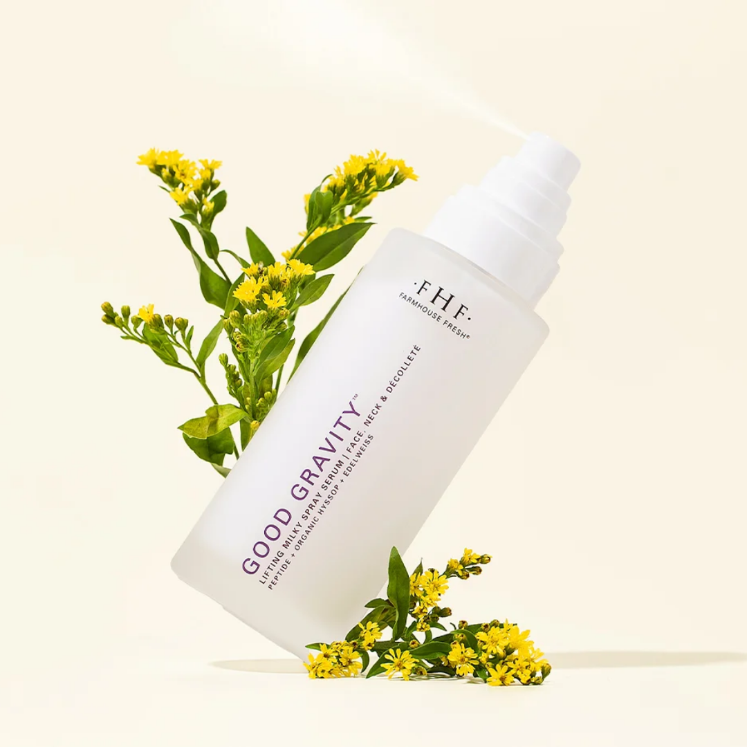 FHF Good Gravity Hyalu-Cica + Resilience Hydration Spray in a frosted white bottle, styled with yellow flowers on a warm cream background.