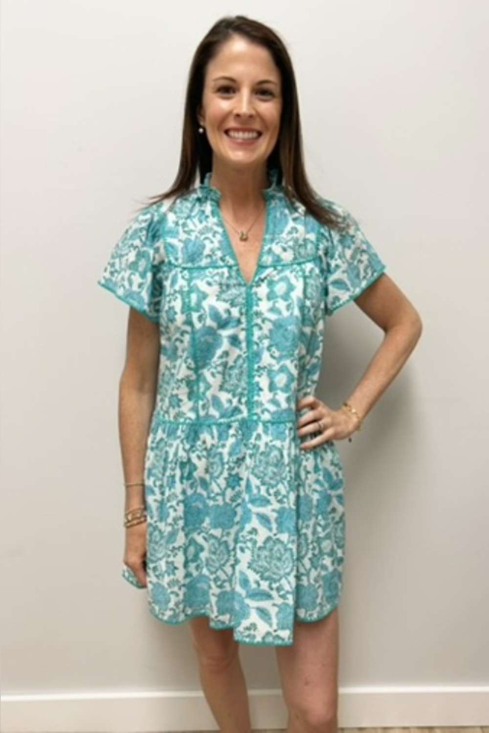 Woman wearing a floral dress against a plain background