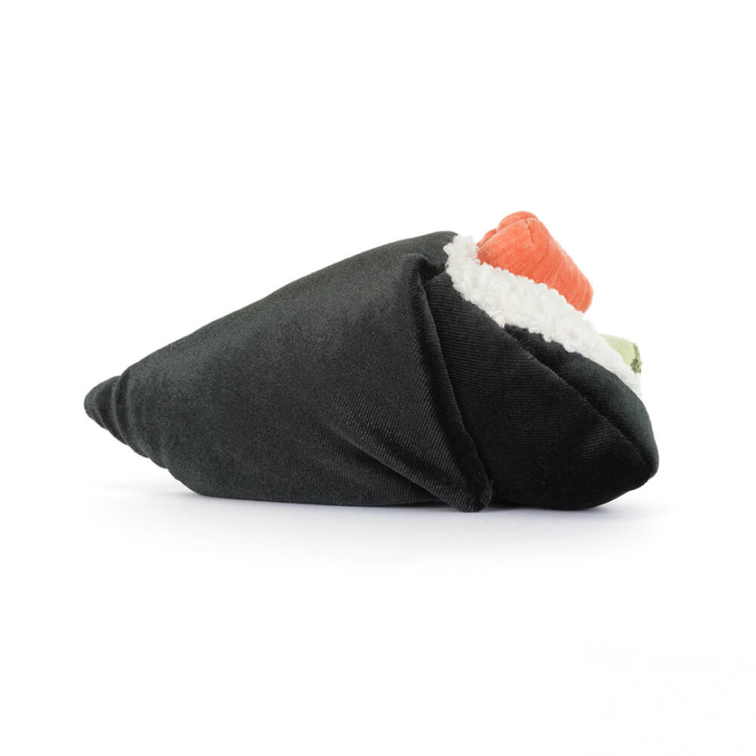 Toy resembling a roll of sushi with black rice, orange fish, and white nori on a white background