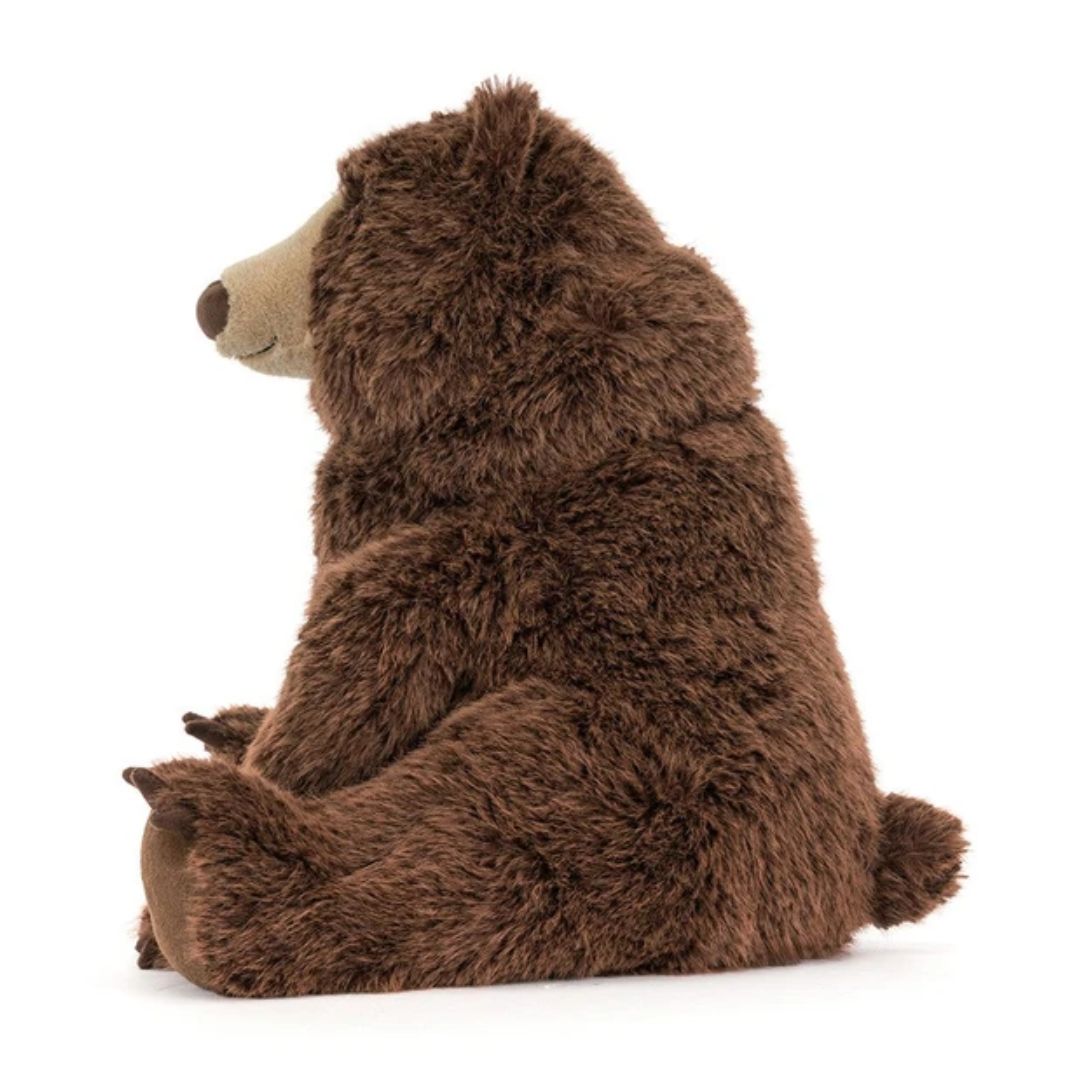 A plush brown bear stuffed animal sitting with its back to the camera, featuring a light tan snout and nose, photographed on a clean white background.