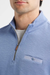 Close-up of a man wearing a light blue quarter-zip pullover with a chest pocket and a white undershirt.
