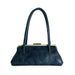 A dark navy blue faux leather handbag with a curved top handle, a kiss-lock metal frame, and a small gold-tone clasp, shown against a plain white background.