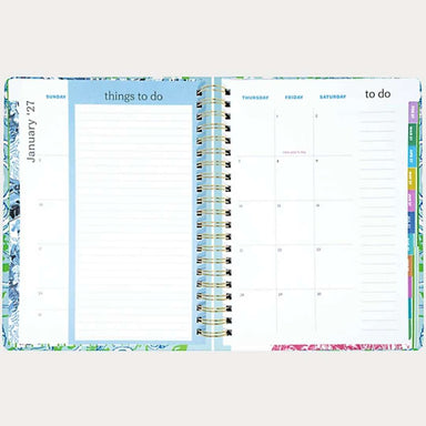 Open planner showing a weekly layout with colorful tabs on a white background