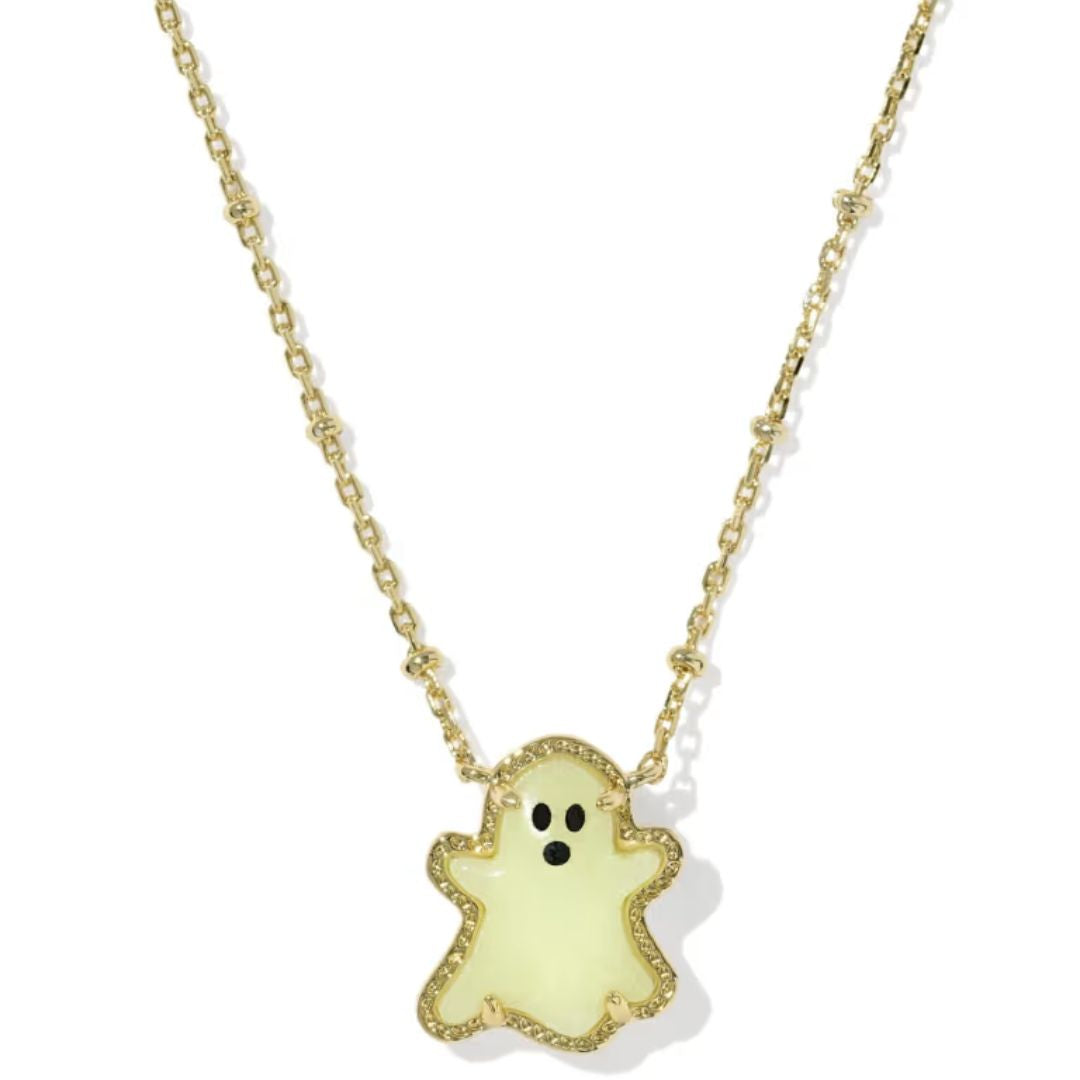 A gold chain necklace featuring a cute ghost-shaped pendant with a pale yellow-green enamel body, black eyes, and a black mouth, outlined in sparkling clear stones.