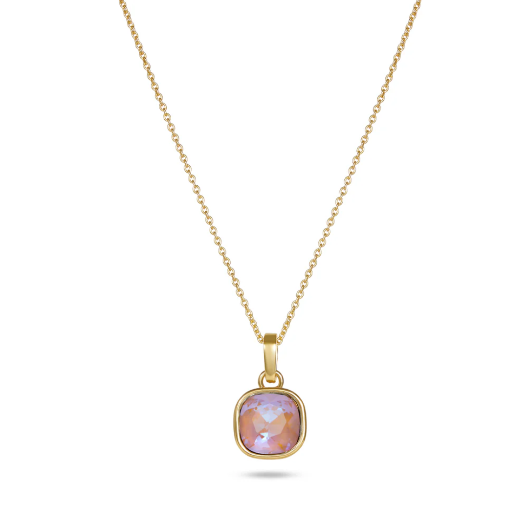 Gold necklace with a pink gemstone pendant on a white background