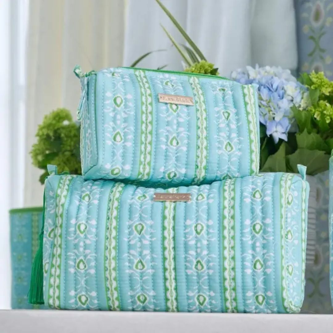 Two turquoise patterned bags with a brand label on a light background