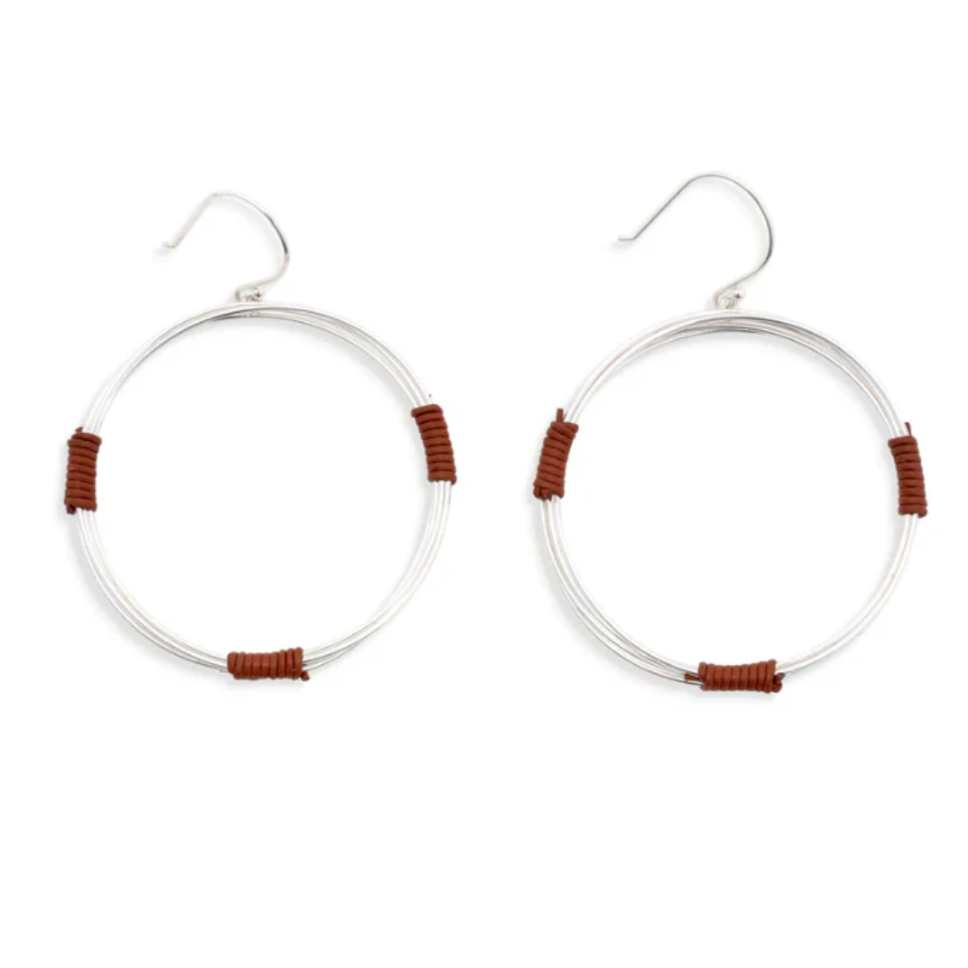 A pair of silver-tone hoop earrings with small brown wrapped accents, shown on a plain white background.