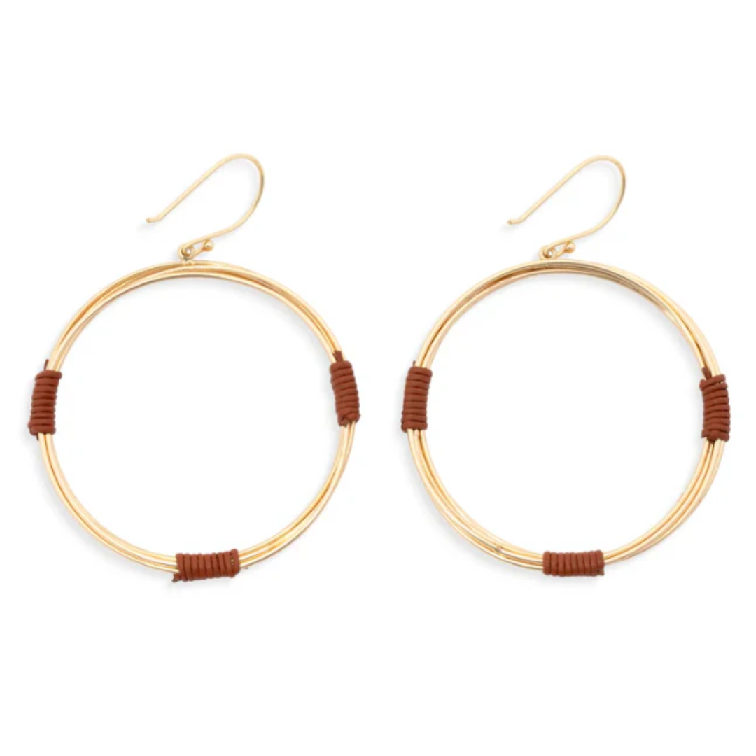 A pair of gold-tone hoop earrings with small brown wrapped accents at the bottom of each hoop, shown on a plain white background.