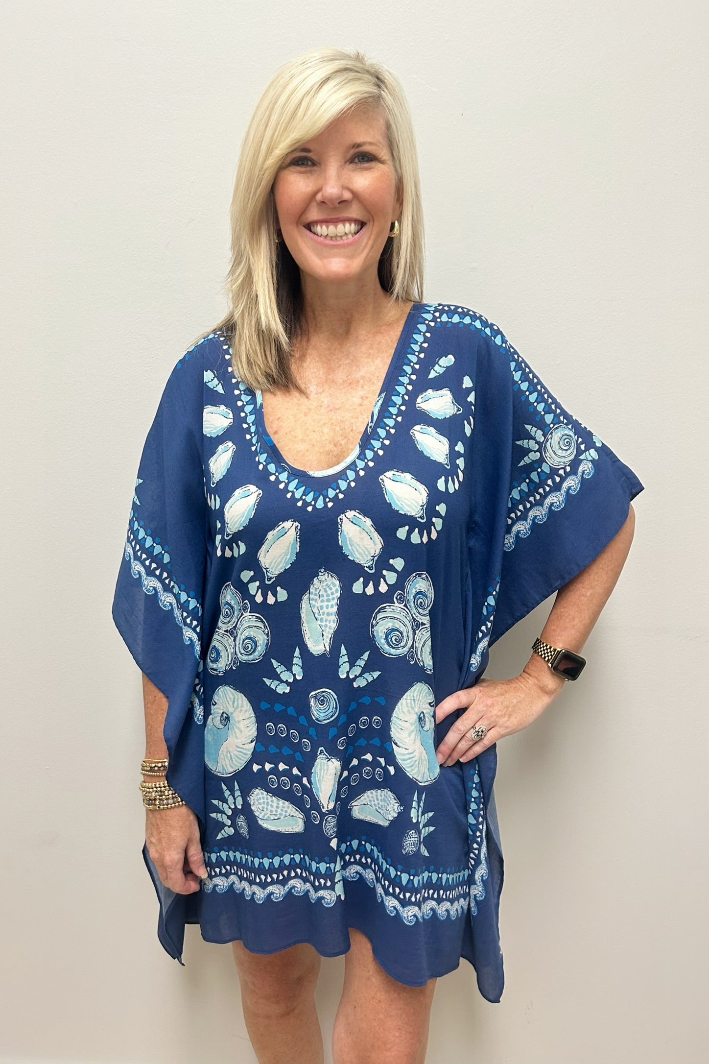 Woman wearing navy blue beach cover-up with sea shell pattern