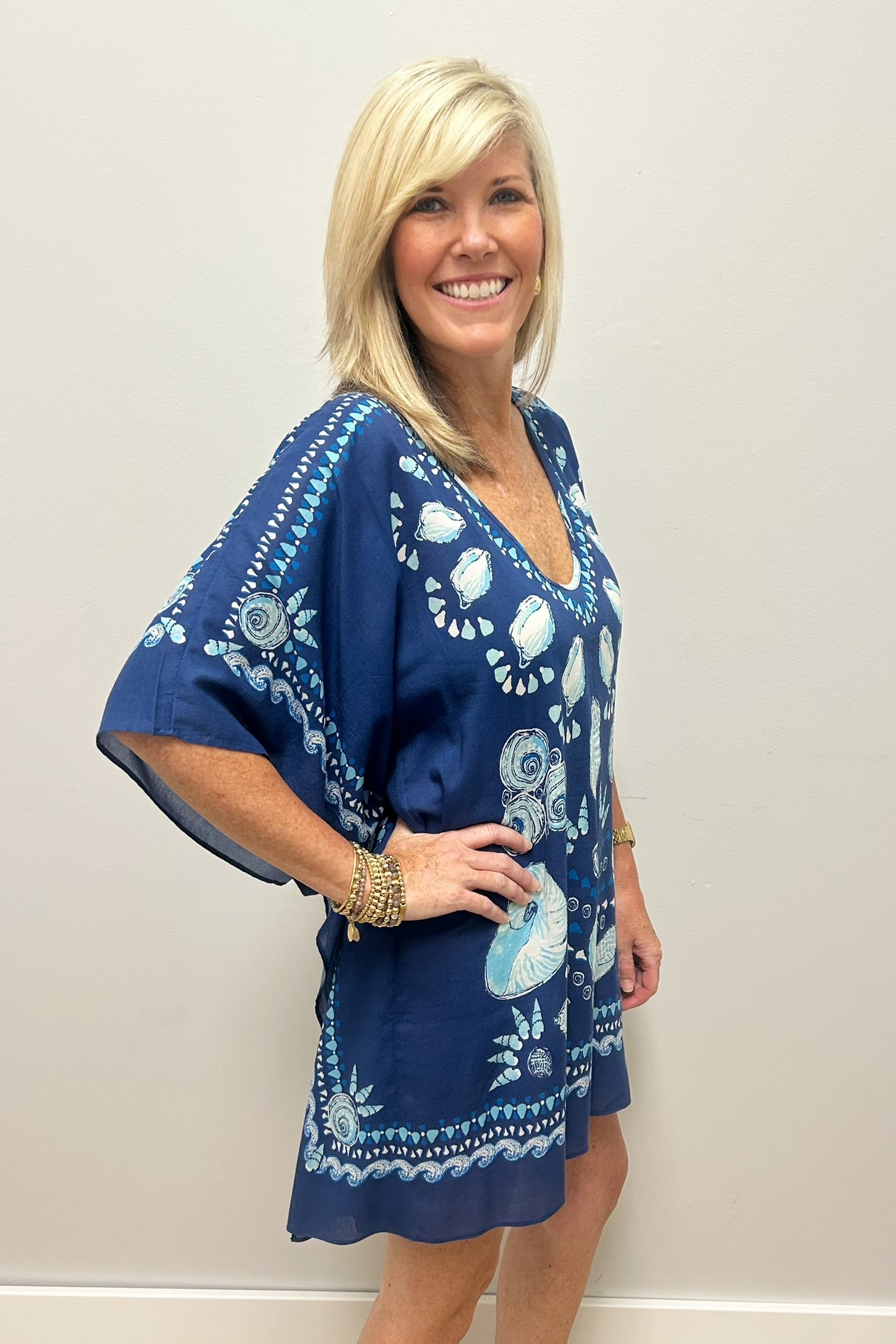 Woman wearing navy blue beach cover-up with sea shell pattern