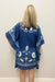 Woman wearing navy blue beach cover-up with sea shell pattern