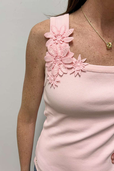 Pink tank top with floral straps worn by a person against a gray background