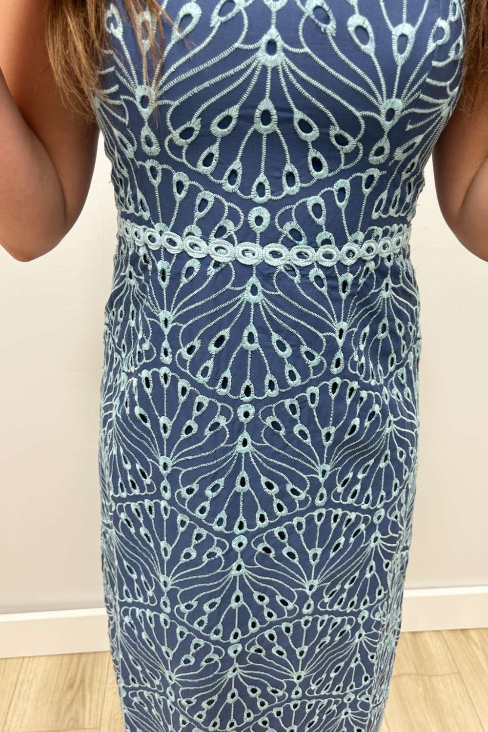 Blue patterned dress worn by a person on a plain background