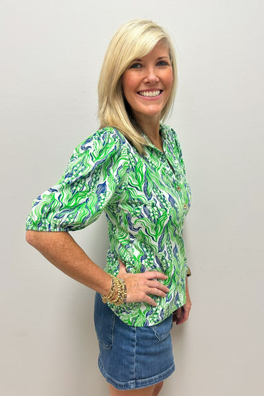 Woman wearing blouse with green and blue pattern with collar