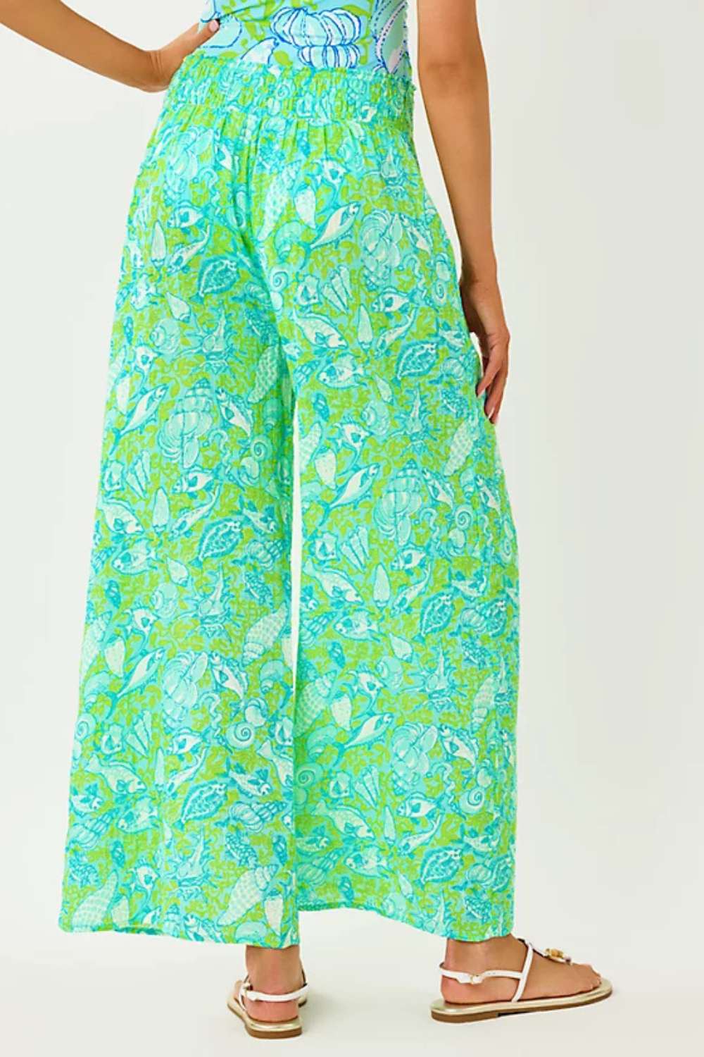 Person wearing a green and blue patterned dress on a white background