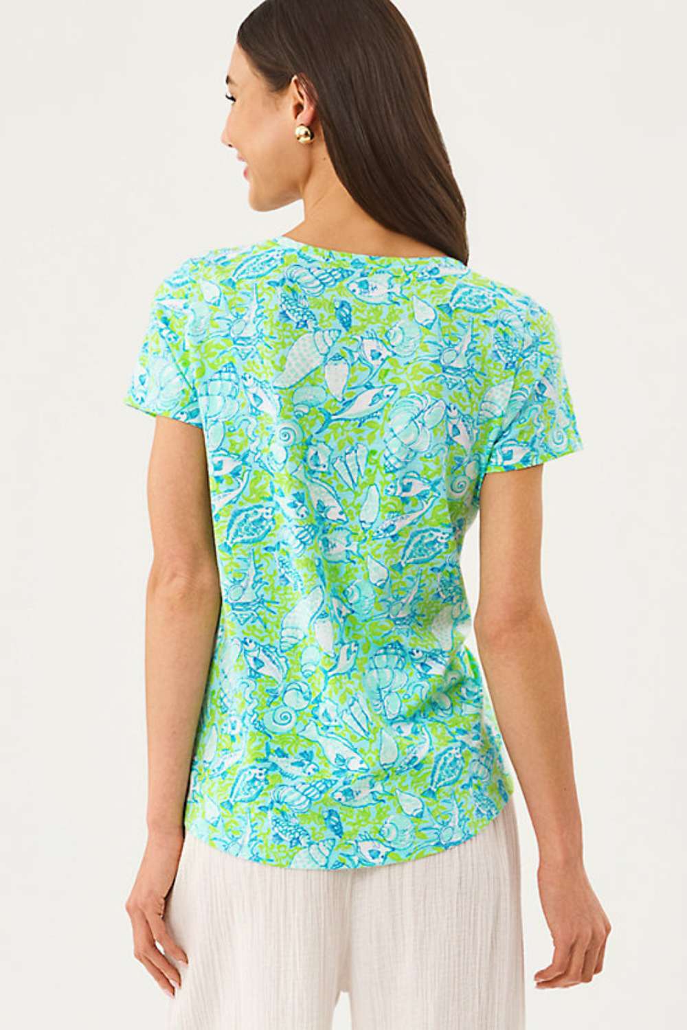 Woman wearing a colorful patterned shirt on a white background