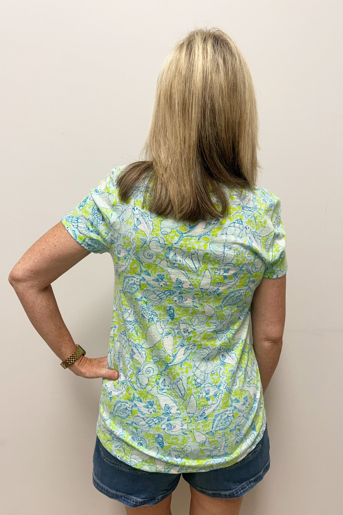 Woman wearing green and blue nautical patterned t-shirt
