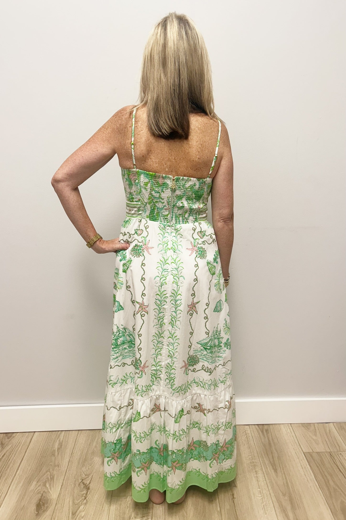 Woman wearing white dress with green and pink patterns