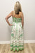 Woman wearing white dress with green and pink patterns