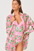 Woman wearing a pink and green floral cover-up on a white background