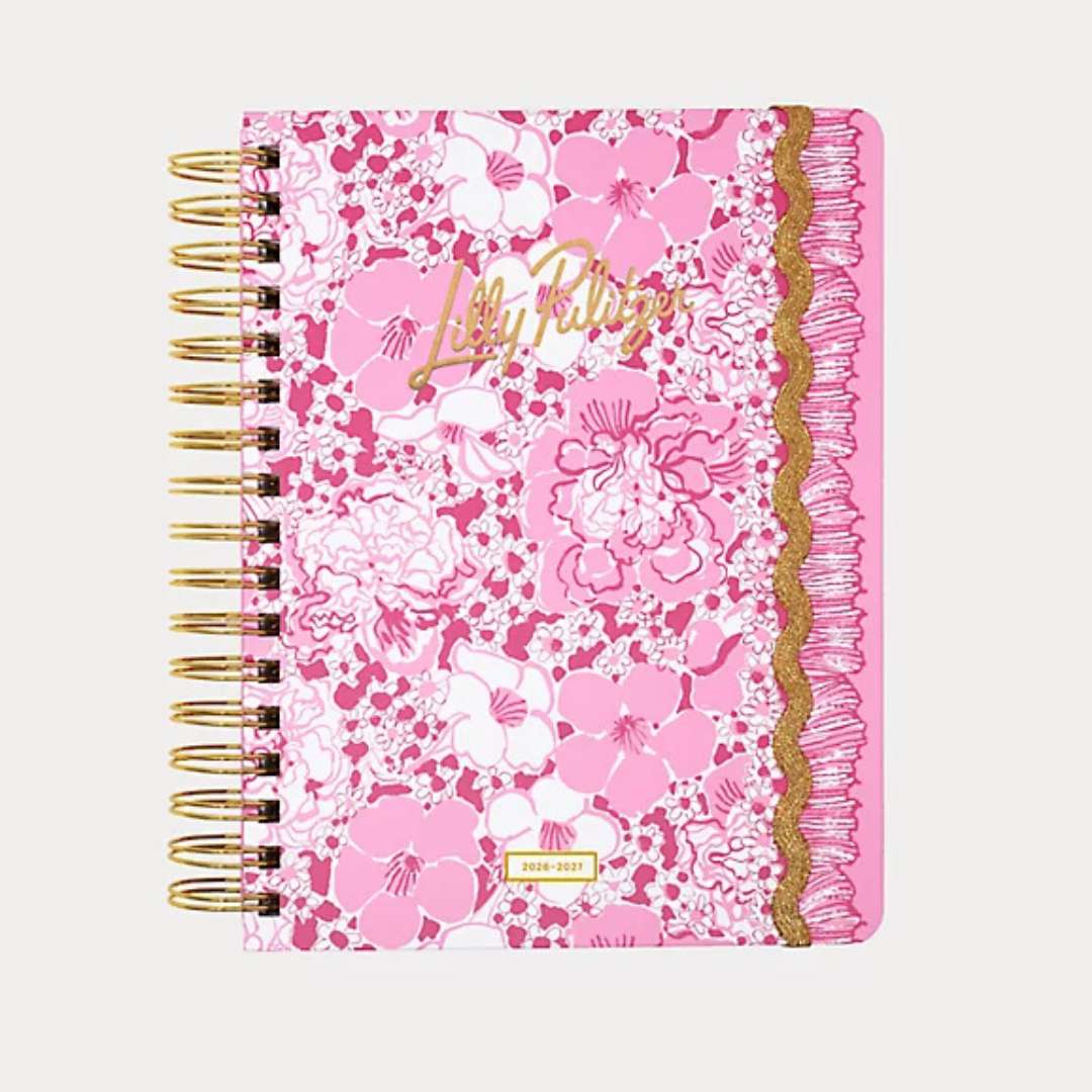 Pink floral notebook with gold trim on a white background