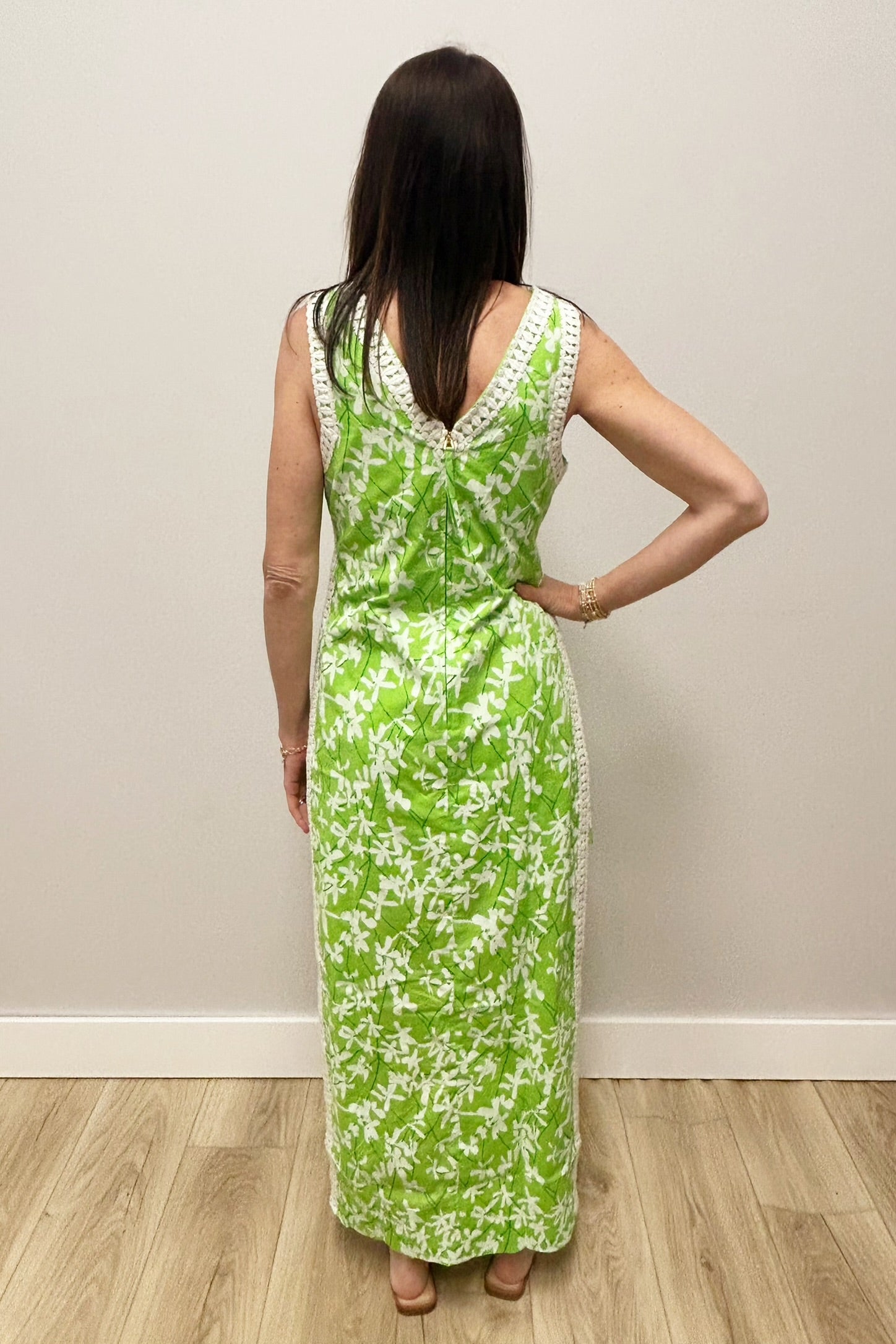 Woman wearing a green floral dress against a plain background
