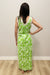 Woman wearing a green floral dress against a plain background