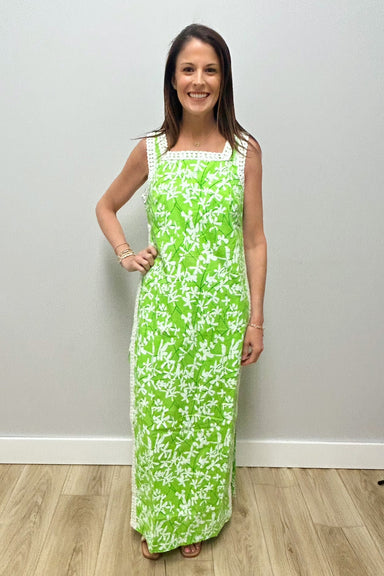 Woman wearing a green floral dress against a plain background