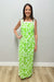 Woman wearing a green floral dress against a plain background