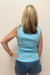 Woman wearing light blue tank top with pearl detail around the neck