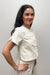 Woman wearing white, short sleeved, button down jacket