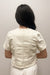 Woman wearing white, short sleeved, button down jacket