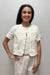 Woman wearing white, short sleeved, button down jacket