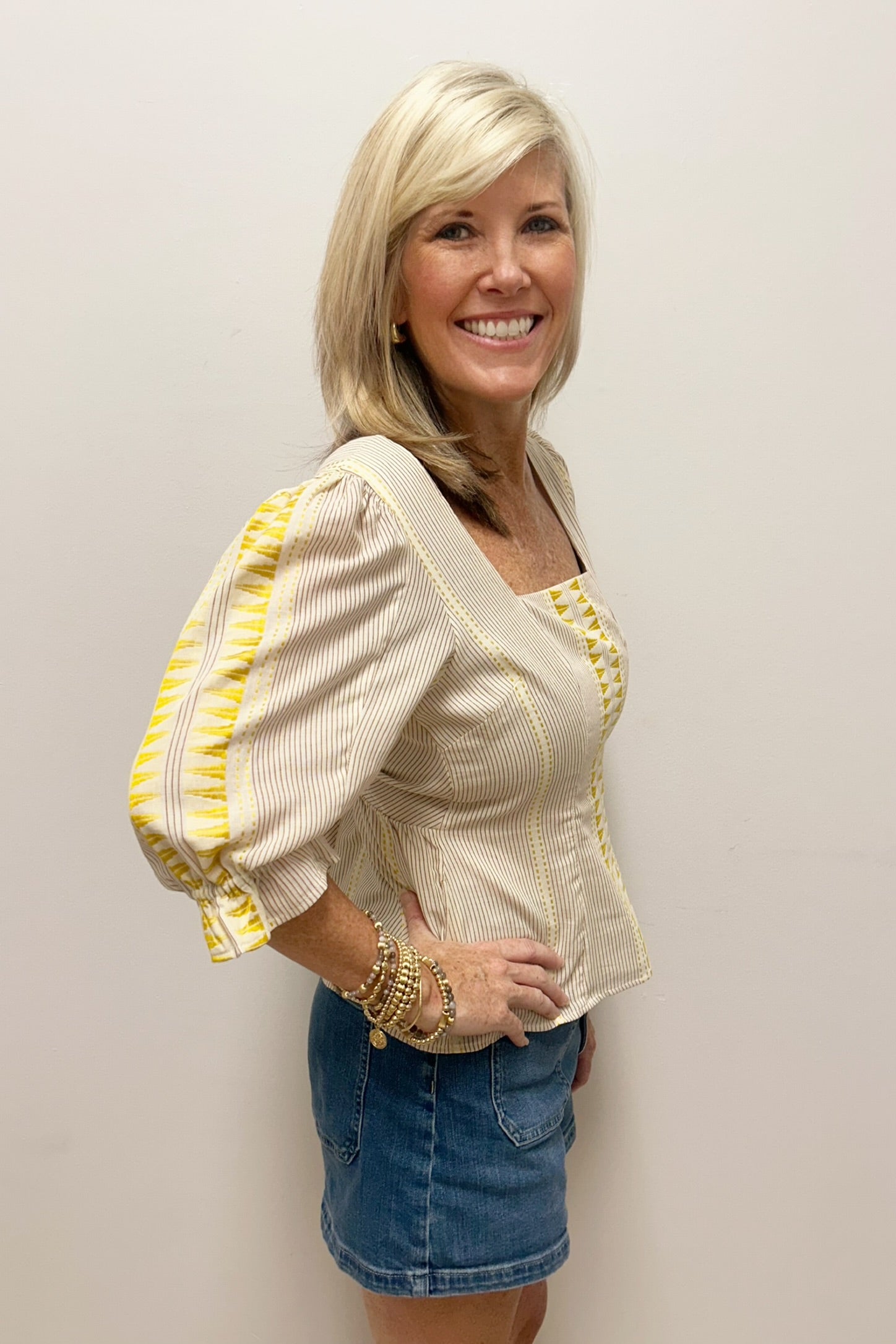 woman wearing yellow and white striped blouse with pattern detail