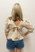 woman wearing yellow and white striped blouse with pattern detail and bow in the back