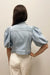 Woman wearing light blue puffed sleeve  denim jacket