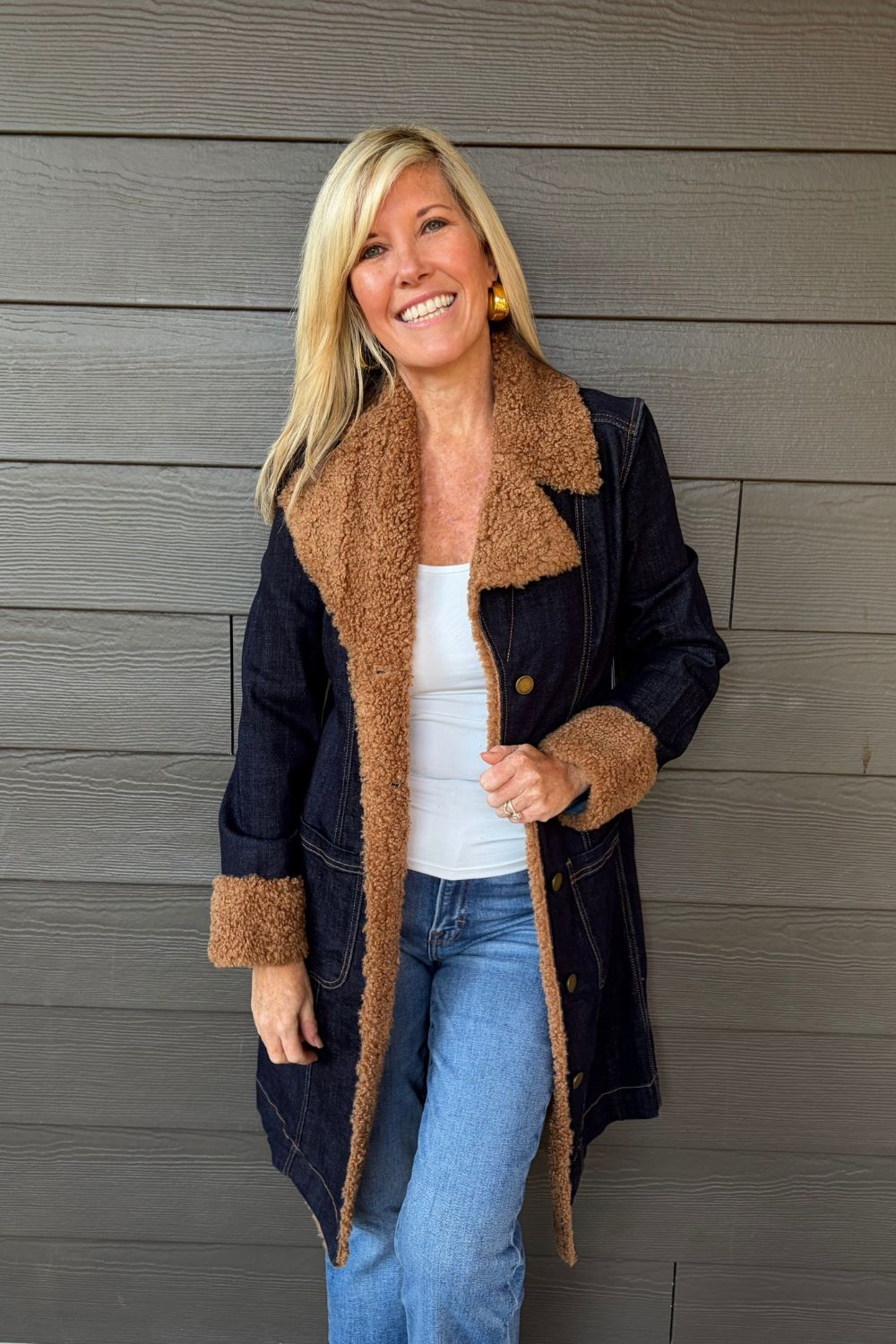 Woman wearing Liverpool Sherpa Notch Collar Jacket In Cinder Bloom with blue jeans on a dark wood background.
