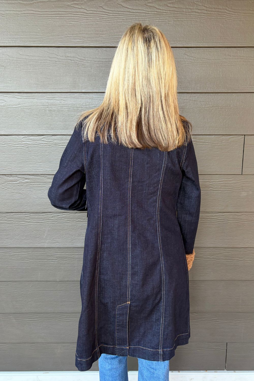 Woman wearing Liverpool Sherpa Notch Collar Jacket In Cinder Bloom with blue jeans on a dark wood background.