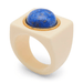 A statement ring featuring a large, matte cream-colored square bezel with a polished blue lapis lazuli sphere set in a gold-tone bezel, shown on a white background.