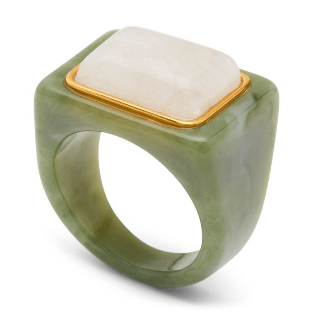A green jadeite ring with a square-shaped white stone and a gold bezel setting, shown on a white background.