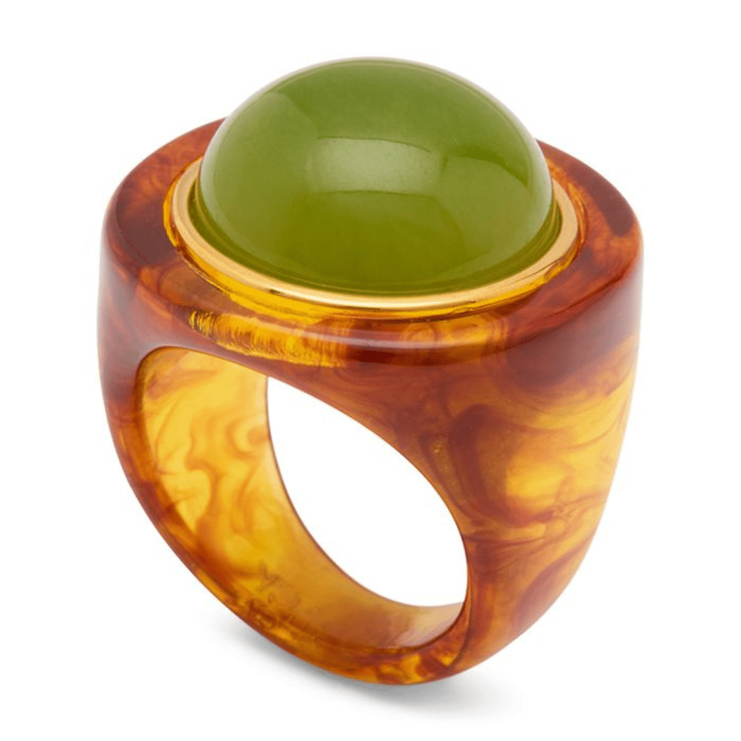 A chunky ring featuring a smooth, polished green dome stone in a bezel setting, surrounded by a thick, marbled amber and orange resin band with a hollow center.