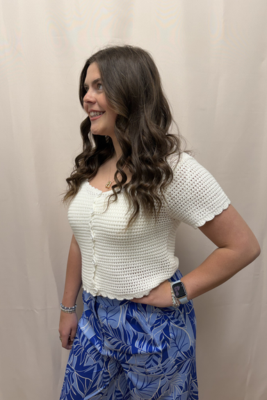 Woman wearing white top and blue pants against.