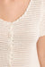 close up of woman in white crochet top with buttons