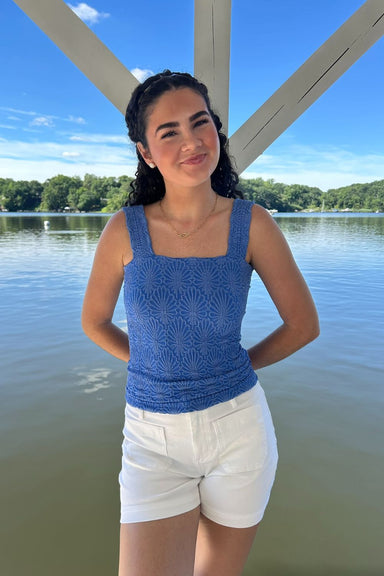 woman in textured blue tank top with a river background