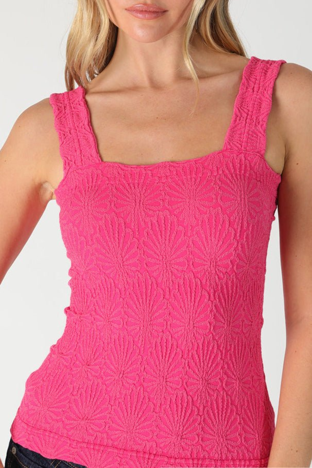 Pink textured tank top worn by a model on a plain background