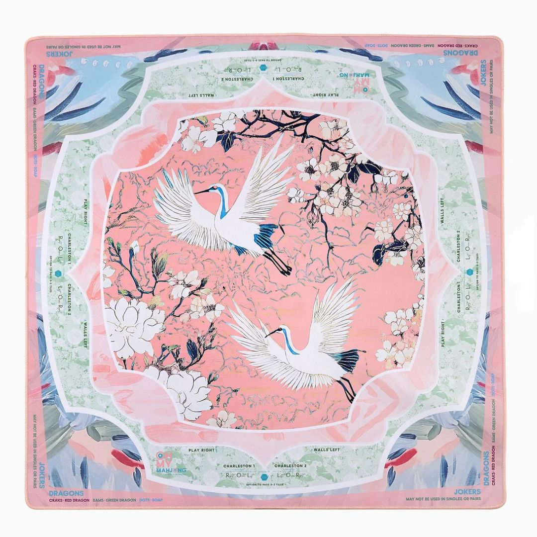 A square silk scarf from the brand Sadori, featuring a pink and light green background with a traditional Japanese crane and cherry blossom design.