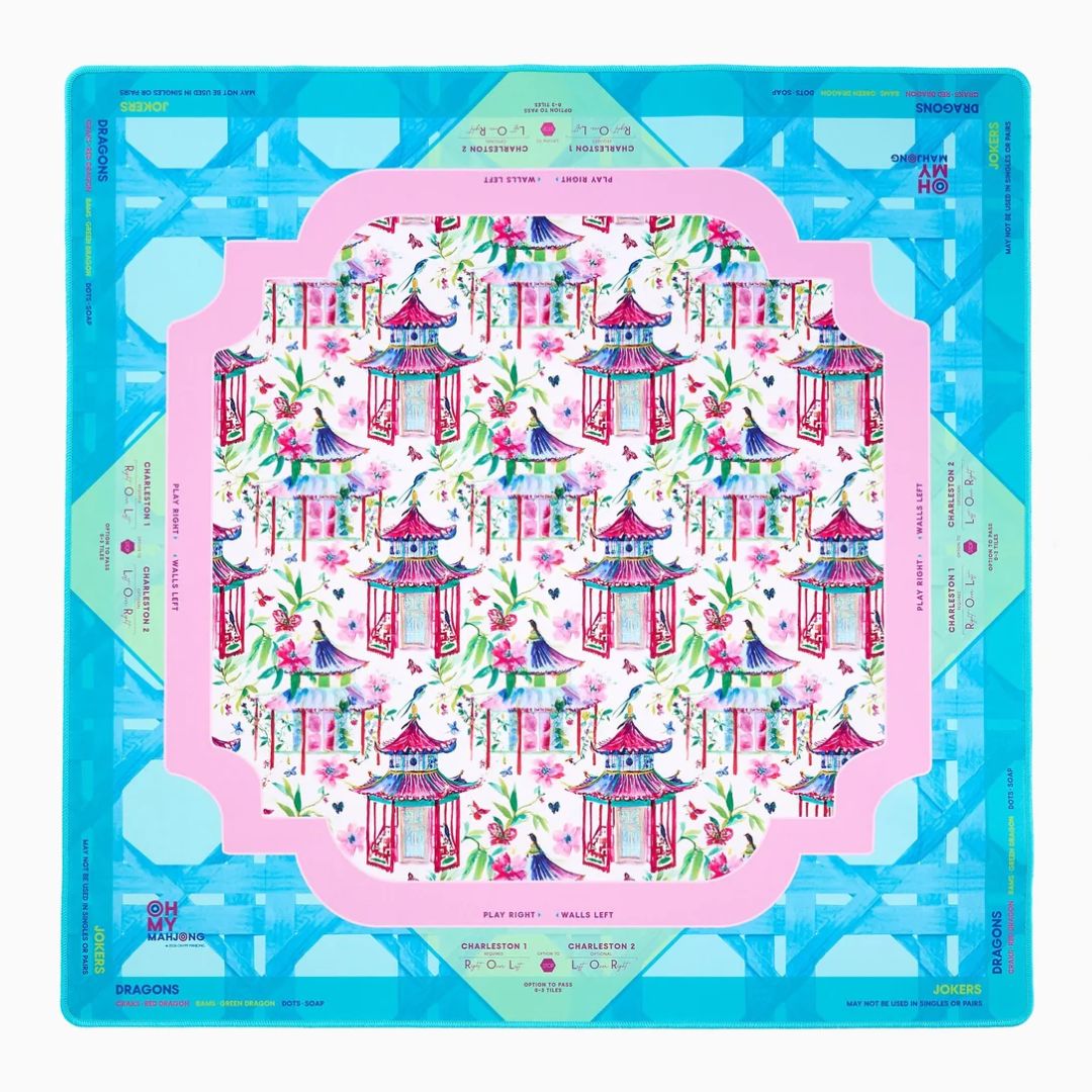 A square silk scarf laid flat, featuring a vibrant traditional Chinese garden pattern with pagodas, cherry blossoms, and cranes. The design is framed by a pink inner border and a bright blue outer border with Chinese characters and decorative motifs.